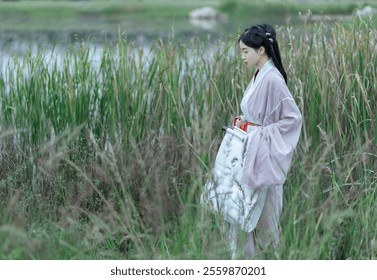 Serene Asian Woman in Traditional Hanfu Strolling Through Peaceful Lakeside Reeds. - Powered by Shutterstock