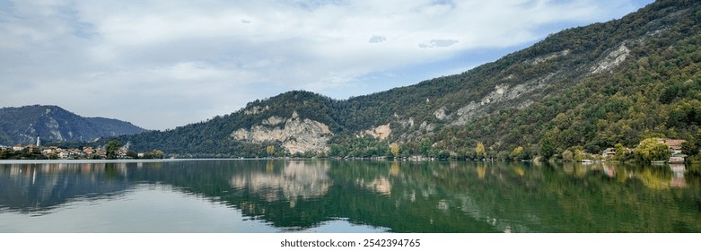 Serene autumn landscape of a tranquil lakeside village surrounded by lush hills, ideal for promoting nature retreats and relaxation getaways - Powered by Shutterstock