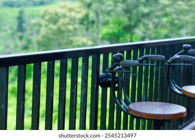 A serene balcony view with stylish chairs overlooking lush green scenery. - Powered by Shutterstock