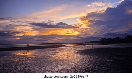 A serene beach at sunset with dramatic clouds and vibrant colors reflecting on the wet sand. Silhouettes of people and trees add to the peaceful atmosphere.