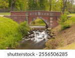 Serene Cascading Stream Flowing Through Scenic Stone Arch Bridge