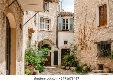 A serene and charming medieval stone alleyway in a picturesque European village decorated with lush plants. Saint Paul de Vence. France. Provence. - Powered by Shutterstock
