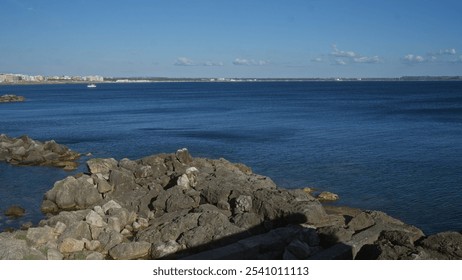 The serene coast of gallipoli in puglia, italy showcases a stunning seascape with rocky shores, clear blue waters, and a distant sailboat under a bright sky. - Powered by Shutterstock