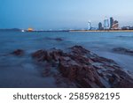 Serene Coastal Cityscape at Dusk with Calm Waters and Urban Skyline  