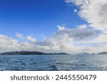 Serene Coastal Cityscape with Fluffy Clouds Overhead