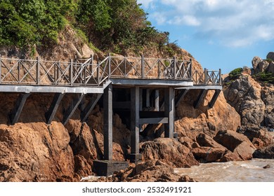 Serene Coastal Pier Surrounded by Rocky Shorelines and Lush Greenery   - Powered by Shutterstock