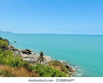 Serene coastal view.  Turquoise ocean meets rocky shoreline. Tranquil beach landscape. Clear blue sky and calm ocean. Stunning turquoise ocean.  Tropical beach scene, Thailand - Powered by Shutterstock