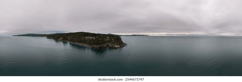 A serene and expansive view of the west coast along Vancouver Island in British Columbia, Canada. This aerial image captures lush forests and calm ocean waters under a cloudy sky. - Powered by Shutterstock