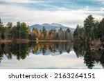 Serene fall landscape of a lake reflection with mountains in the distance of Jeffersonville, Vermont