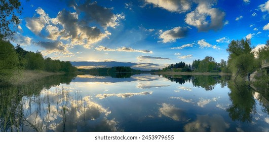 Serene Fishing Lake: A peaceful scene by the tranquil waters of a secluded fishing lake. Surrounded by lush greenery and framed by a clear blue sky, this picture captures the essence of a perfect day  - Powered by Shutterstock