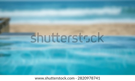 A serene infinity pool with clear blue water meets a sandy beach and the vast ocean under a bright sky.