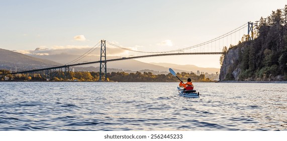 A serene kayaking experience during a sunrise near the iconic suspension bridge in Vancouver, surrounded by nature. - Powered by Shutterstock