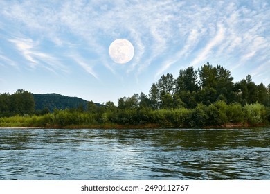 A serene landscape featuring a full moon rising over a lush, green forest with a calm river in the foreground, set against a beautiful, clear sky with wispy clouds.