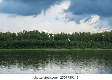 Serene landscape of forest and calm lake, with reflections of trees on the water. - Powered by Shutterstock