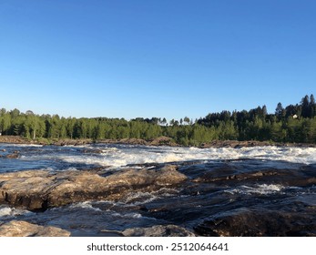 A serene landscape of a rushing river surrounded by lush forest and a clear blue sky, symbolizing the power and tranquility of nature. - Powered by Shutterstock