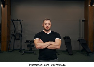 Serene Male Athlete Posing For Camera Among Fitness Equipment