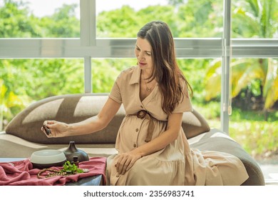 A serene moment captured as a pregnant woman after 40 embraces the soothing benefits of aroma oils and an aroma diffuser, enhancing her pregnancy journey with relaxation and tranquility - Shutterstock ID 2356983741