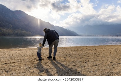 A serene moment capturing a father and child walking along a lakeside in Harrison Mills, BC, Canada. The scene embodies connection, nature, and tranquility. - Powered by Shutterstock