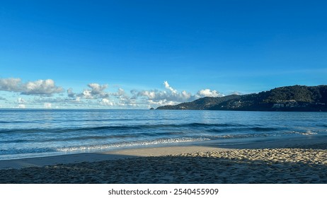 Serene Morning at the Beach: Gentle Waves, Clear Skies, and Lush Hills in the Distance - Powered by Shutterstock