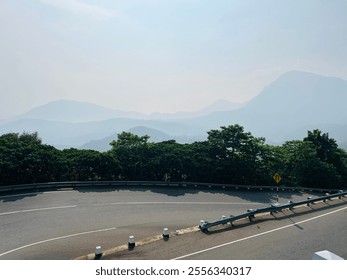 A serene morning view of Sri Lanka’s famous 18-bend road, surrounded by misty mountains. The winding road offers breathtaking scenery, lush greenery, and crisp, refreshing air at dawn. - Powered by Shutterstock