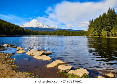 Serene Mount Hood Lake with Snow-Capped Peaks and Rocky Shoreline - Powered by Shutterstock