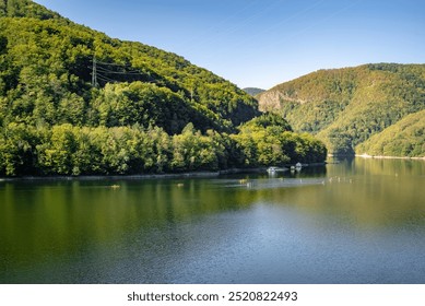 Serene Mountain Lake with Lush Green Forests, Kayakers and Canoeists in a Peaceful Natural Landscape - Summer Outdoor Adventure - Powered by Shutterstock