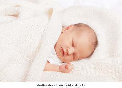 Serene newborn baby girl sleeps comfortably wrapped in soft cream blanket - Powered by Shutterstock