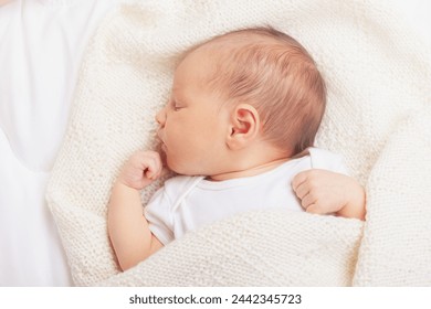 Serene newborn baby girl sleeps comfortably wrapped in soft cream blanket - Powered by Shutterstock