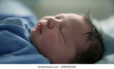 Serene newborn baby sleeping in a blue onesie, swaddled in soft blankets in a hospital bed, focus on the baby's peaceful expression, capturing the tranquility of newborn life - Powered by Shutterstock