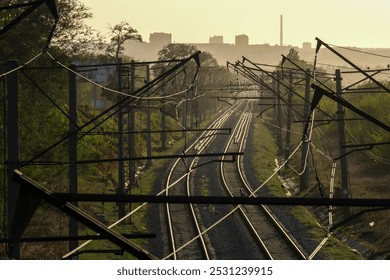 A serene and peaceful representation of winding railway tracks stretching into the horizon under a stunning sunset - Powered by Shutterstock