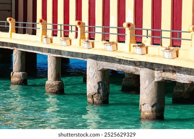 Serene pier featuring a wooden bench overlooking calm sea water. Terrace on the water on Mondello beach in Palermo - Powered by Shutterstock