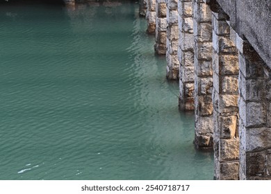 Serene Reflections: Stone Bridge Pillars Mirrored in Tranquil Waters - Powered by Shutterstock