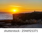 A serene Santa Cruz beach bathed in the warm glow of a coastal sunset.