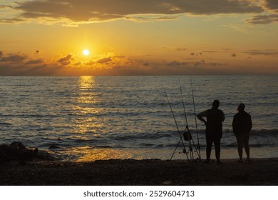 A serene scene of a person fishing by a calm Aegean sea at sunset, capturing a moment of peace and reflection with the golden glow of the setting sun over calm waters. - Powered by Shutterstock