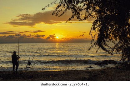 A serene scene of a person fishing by a calm Aegean sea at sunset, capturing a moment of peace and reflection with the golden glow of the setting sun over calm waters. - Powered by Shutterstock