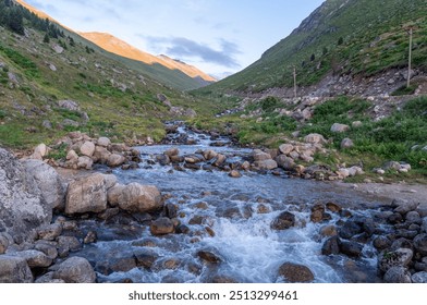 A serene stream flowing through the lush green landscape of Amaklit Plateau in Camlihemsin, showcasing the natural beauty of the highlands with rocks and hills under a clear sky. - Powered by Shutterstock