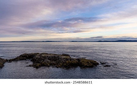 Serene sunrise over the rocky shores of Victoria, Vancouver Island, BC, Canada, with a calm sea and colorful sky. Perfect for nature and travel themes. - Powered by Shutterstock