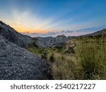 Serene sunset view over the Pedras Negras Mountains showcasing the rugged terrain and vibrant sky in Angola