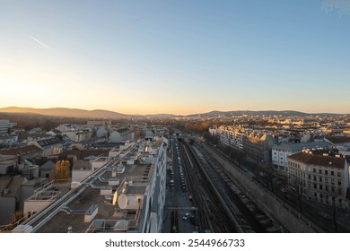 A serene sunset view over Vienna with the Wienfluss canal, rooftops, and distant hills. - Powered by Shutterstock