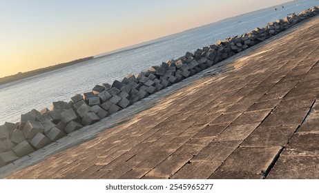 A serene view of the Bakkhali River in Cox's Bazar district at sunset, with a traditional boat sailing on calm waters. The golden hues of the setting sun create a picturesque and tranquil scene. - Powered by Shutterstock