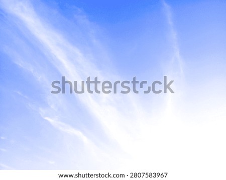 Serene view of wispy white clouds drifting across a vast light blue sky with ample negative space for text with background bright natural captures wispy environment