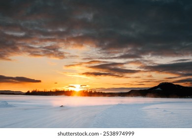 Serene winter landscape at sunset with dramatic clouds and snow-covered ground, creating a peaceful scene of nature’s beauty and tranquility - Powered by Shutterstock