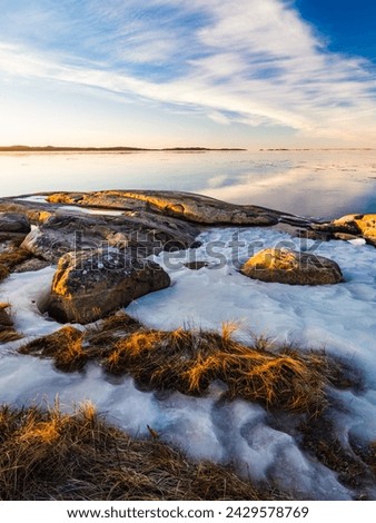 Serene Winter Sunset at Sillvik, Sweden With Frozen Shoreline and Calm Sea
