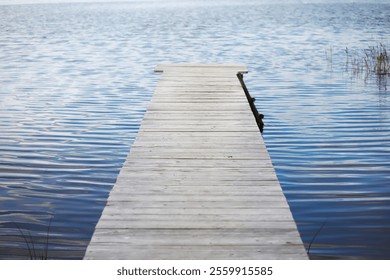 Serene Wooden Dock Extending over Calm Lake Waters in Peaceful Nature Setting - Powered by Shutterstock