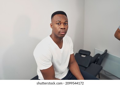 Serene Young Man Seated In Physiotherapist Office