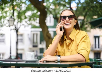 Serene Young Woman Talking On Mobile Phone Sitting In Summer Cafe Outside, Carefree Attractive Lady In Sunglasses Enjoys Pleasant Phone Conversation Outdoors