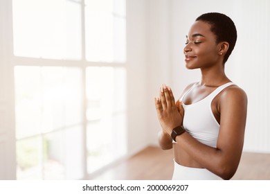 Serenity And Mindfulness Concept. Portrait Of Calm Smiling African American Female Holding Hands In Prayer Pose, Keeping Palms Together, Meditating, Practicing Kundalini Yoga. Free Copy Space