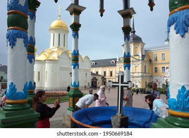 Sergiyev Posad, Russia - June 26, 2019: Chinese tourists taking photo at Holy water spring under colorful canopy at Trinity Lavra of St. Sergius. Russian christian architecture