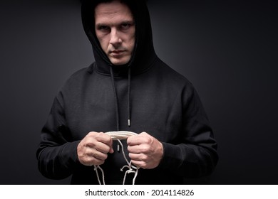 Serial killer with rope in hands, looking at camera, commit crime, isolated on black studio. aggression, crime concept. Portrait of caucasian male pedophile maniac, copy space. kidnapping, violence