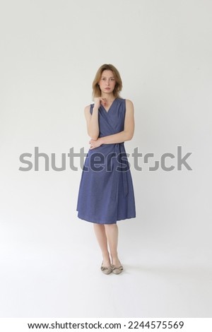 Serie of studio photos of young female model in cotton denim wrap sleeveless dress.